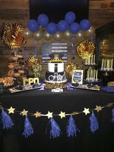 a table topped with a cake and balloons