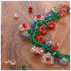 beaded flowers on a wooden surface with beads scattered around the area and in between them