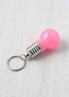 a pink light bulb shaped keychain on a white surface