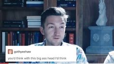 a man is sitting in front of a book shelf