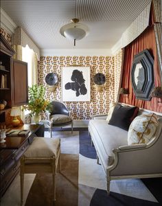 a living room filled with furniture next to a wall covered in pictures and paintings on the walls