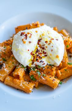 a white plate topped with pasta covered in cream