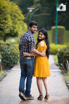 a man and woman are standing in the rain with their arms wrapped around each other