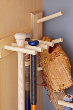 a baseball glove, mitt and other sports equipment hanging on a wall next to a door