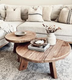 a living room with a couch, coffee table and pillows on the floor in front of it