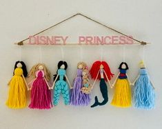 the disney princesses are hanging on the wall with tassels attached to them