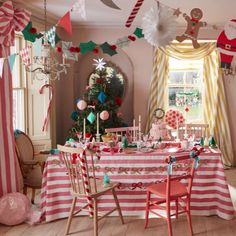 a decorated christmas table in a pink and white room