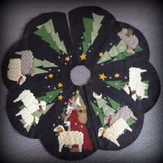 a black christmas tree skirt with sheep and stars on it