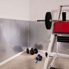 there is a gym equipment set up in the corner with a blue mat on the floor