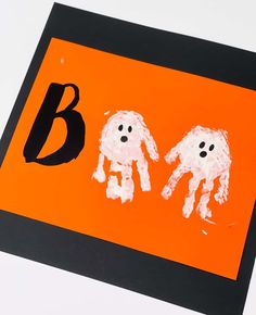 an orange and black letter b with two white dogs on it