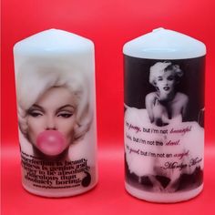 two candles with marilyn monroe pictures on them, one is pink and the other is white