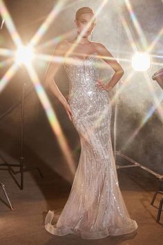 a woman in a white dress posing for the camera with her hands on her hips