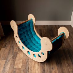 a child's wooden rocking chair with blue cushions on the bottom and back sides