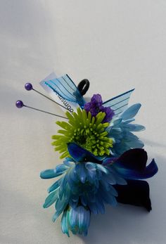 a bouquet of blue and green flowers on a white surface