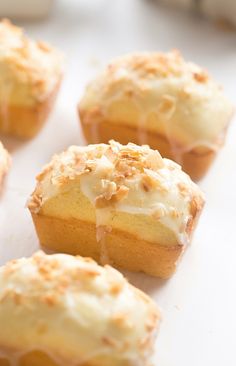 several muffins with white frosting and sprinkles on them sitting on a table