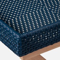 a close up of a blue and white woven table cloth on top of a wooden stand