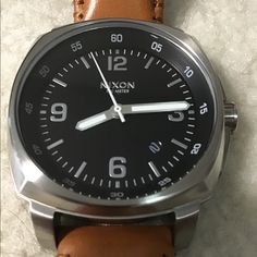 This Is A Beautiful, Near Mint Condition Men's Watch That Goes Well With Blue Denim, Khakis Or Summer Wardrobe. I Suppose You Could Wear It With A Tuxedo, But I Would Recommend White Or Cream Color. The Band Is Light Tan Color, Almost Orange But Not Quite. It's A Rare Nixon Watch That Is No Longer Made And I'm Sure You Will Like It. I Bought This On Poshmark And Then Took It To A Professional Watch Shop And Had A Battery Installed. In No Hurry To Sell Unless Price Can Be Met. Casual Watch Accessories With Analog Display For Everyday Use, Casual Brown Watch Accessories With Leather Strap, Brown Watches With Subdials For Everyday Use, Casual Leather Watch Accessories For Everyday Use, Masculine Everyday Watch Accessories, Brown Everyday Watches With Subdials, Casual Leather Watch With Round Dial, Casual Watches With Leather Strap For Everyday Use, Brown Casual Watch Accessories For Everyday Use