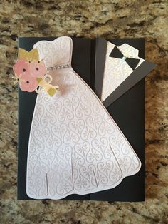 wedding card with bride's dress and groom's boutonniere on it