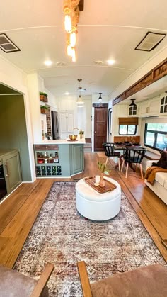 a living room filled with furniture and a rug on top of a hard wood floor