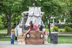 a little boy standing in front of a fake pirate ship on the side of a road