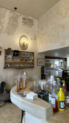 a counter with dishes and bottles on it in a room that looks like an old house