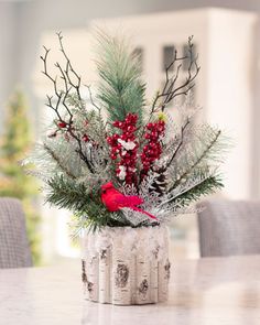 a vase filled with branches and berries on top of a table