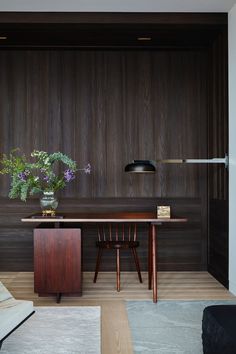 a room with wooden paneling and a table in the center, surrounded by two chairs