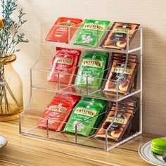 a stack of tea bags sitting on top of a wooden table next to a vase