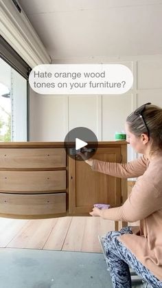 a woman sitting on a chair in front of a dresser with the caption hate orange wood tones on your furniture?