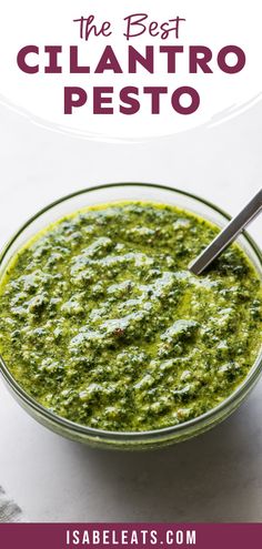 the best cilantro pesto recipe in a glass bowl with a spoon inside