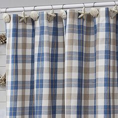 a blue and white checkered curtain with seashells on it