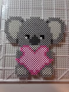 a cross stitch teddy bear with a pink heart