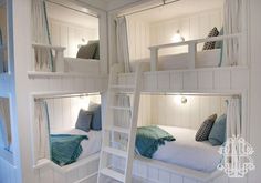 the bunk beds are all white and have blue pillows