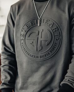 This SteelHeart Signature Embossed Sweatshirt with embossed SH emblem logo on front and lettering on the sleeve is unlike any other sweatshirt and makes a bold statement. High quality, top tier, breathable and anti-shrinkage fabric is what makes this sweatshirt so exquisite. Designed down to the very last detail like the different color collar and sleeve cuff, this custom piece will have you looking great and feeling even better. Snag this sweatshirt in one of the 3 versatile color ways and styl Event Merch, Embossed Sweatshirt, Black Creators, Athleisure Lifestyle, Heart Clothing, Urban Island, Creative T Shirt Design, Jacket Collection, Tshirt Printing Design