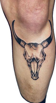 a bull's skull tattoo on the side of a man's calf leg