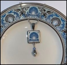 "BROKEN CHINA JEWELRY, SQUARE PENDANT NECKLACE, WEDGWOOD BLUE DOLPHINS PLATE Beautiful Shell Design Perfect Cruise Jewelry Made from a Vintage China Plate Pendant Measures 3/4\" X 2\", including Pearl and Crystal Dangle Includes Antiqued Sterling Bail and Silverplated Chain This listing is for a hand-crafted, \"broken china\" necklace. This piece has been created by artistically repurposing a vintage Wedgwood Blue Dolphins china plate. The china square pendant measures 3/4\" in width by 2\" in h Cruise Jewelry, Bridal Traditions, Shabby Chic Jewelry, Wedgwood Blue, Antique Plates, Broken China