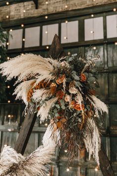 an arrangement of dried flowers and greenery hangs from the ceiling