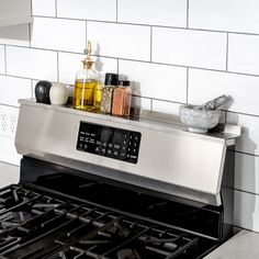 a stove top oven sitting inside of a kitchen next to a white tiled countertop