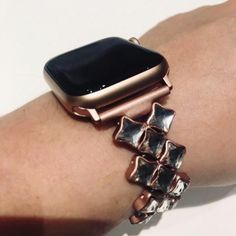 an apple watch on someone's arm with some bracelets attached to the wrist