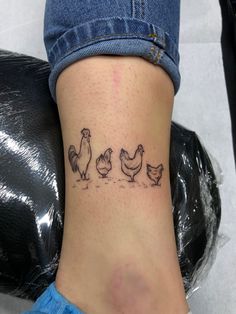 a woman's foot with three chickens on it