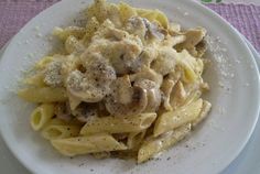 a white plate topped with pasta covered in mushrooms