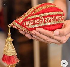 a person holding a red and gold decorative item