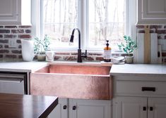 a kitchen sink sitting under a window next to a counter