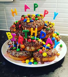 a birthday cake made to look like donuts with chocolate frosting and sprinkles