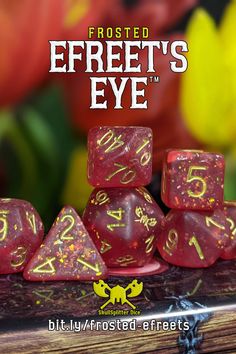 frosted red and yellow speckled dice with gold numbers on them, sitting on a wooden table