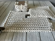 two knitted baskets sitting on top of a wooden table next to a bottle opener