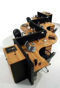 an office desk with chairs and laptops on it in the middle of a room