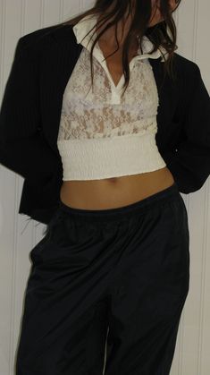 a woman in black pants and a white top is posing for the camera with her hands on her hips