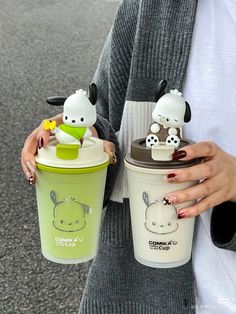 the woman is holding two cups with animals on them and one has a straw in it