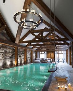 a large indoor swimming pool with lights hanging from it's ceiling and chandelier